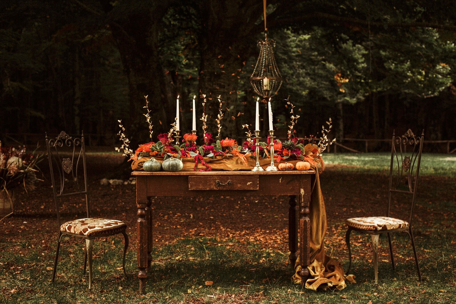 Tavolo decorato con centrotavola autunnale in un set naturale con sedie e altre decorazioni autunnali